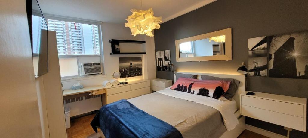 een slaapkamer met een bed, een bureau en een raam bij Medium size room for 2 in Toronto