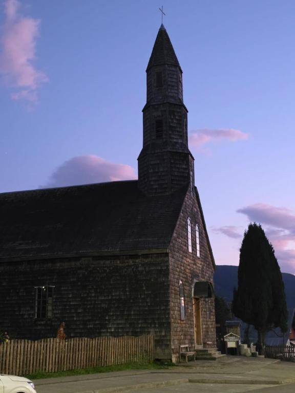 an old brick church with a tower on top at Cabañas cochamó in Cochamó