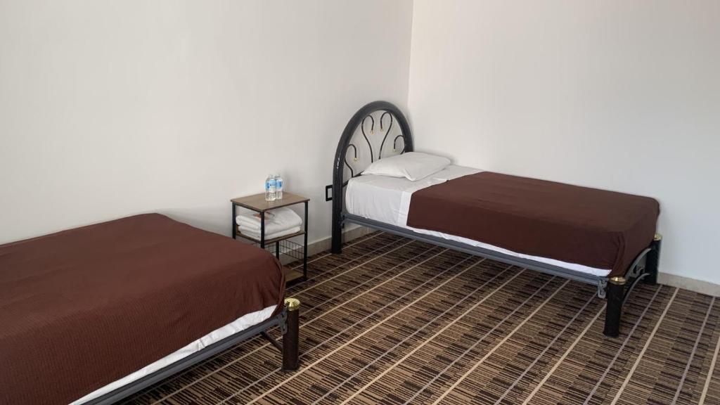 a bedroom with two beds and a side table at Kuku Ruku Hotel in Querétaro