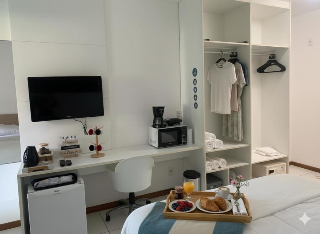 a bedroom with a tray of food on a bed at Iloa Studio Alagoas sofisticação de alto padrão in Barra de São Miguel