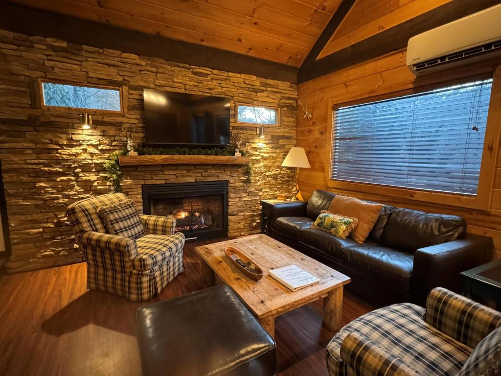 un soggiorno con mobili in pelle e un camino di Hummingbird Hideaway - Lake Pets Hike Fish a Hidetown