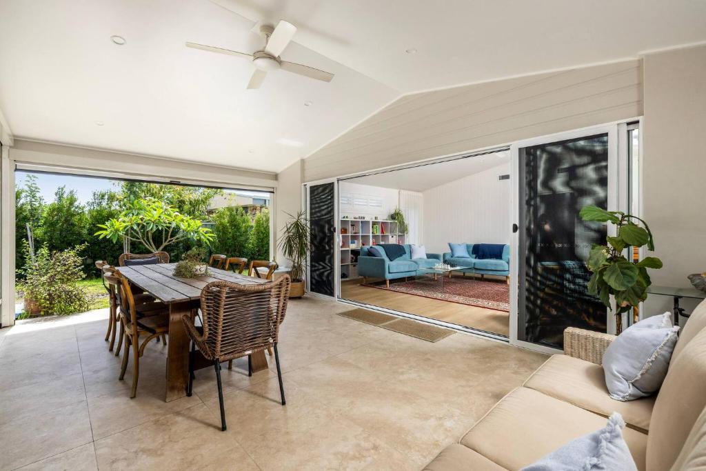 a dining room with a table and a couch at Verona in Shoal Bay