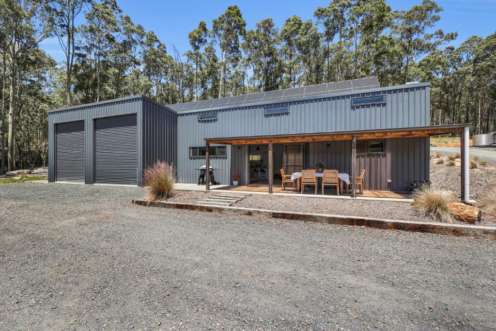 a modern home with a metal building with a patio at Tathra Bermagui Road 613 in Tathra
