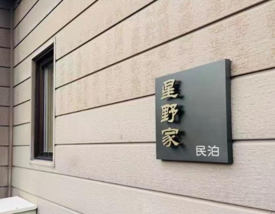 ein Schild an der Seite eines Gebäudes in der Unterkunft 富良野 星野家 in Furano