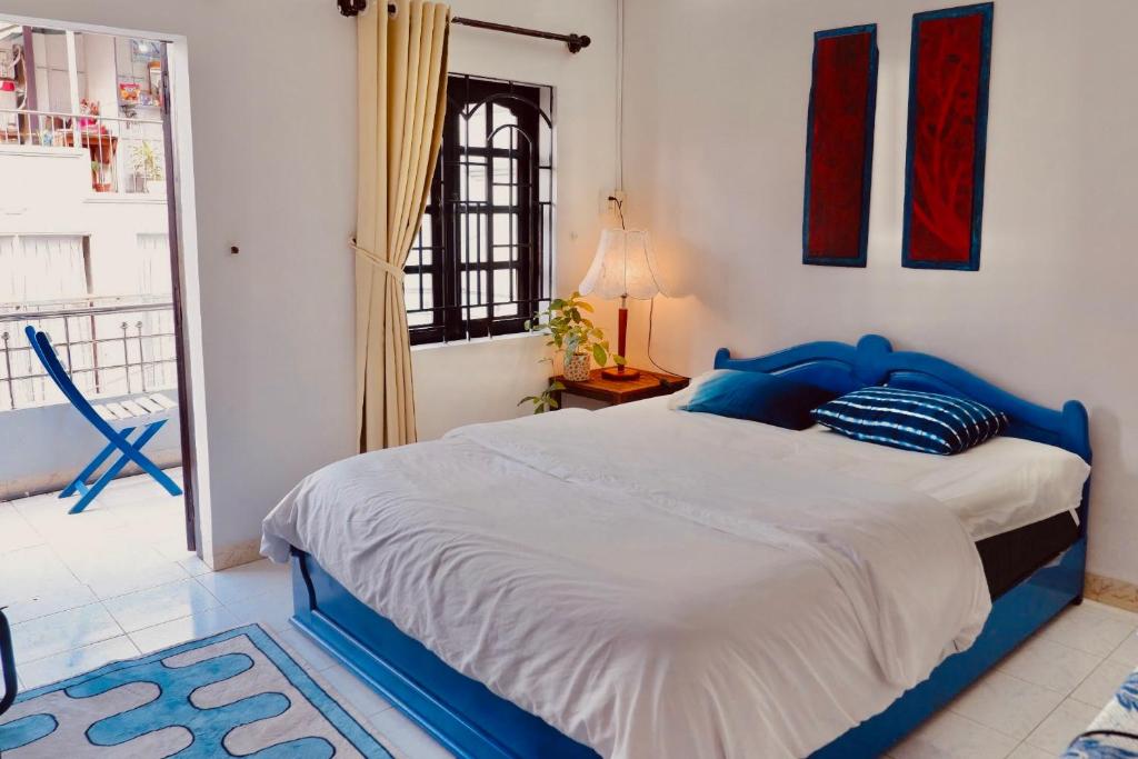a bedroom with a blue and white bed and a window at KUHA home in Nha Trang