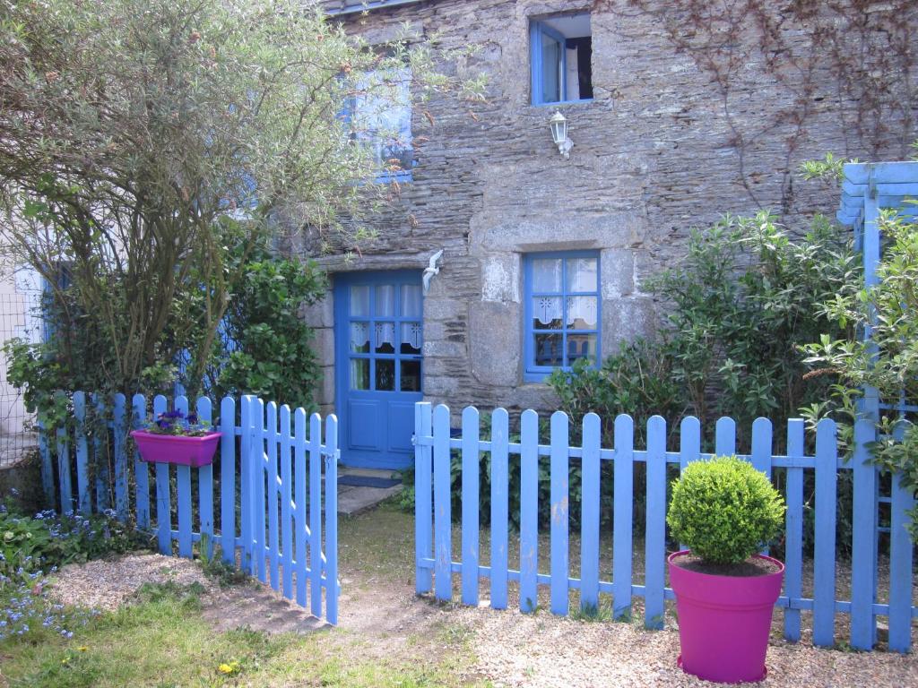 a white picket fence in front of a house at Gîte Les Lutins Bleus in Guillac