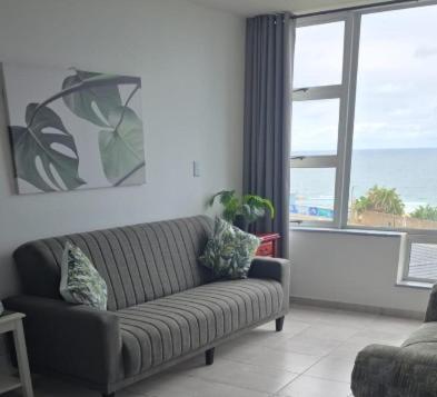 a living room with a couch and a large window at Peacehaven's Finest View 107 in Scottburgh