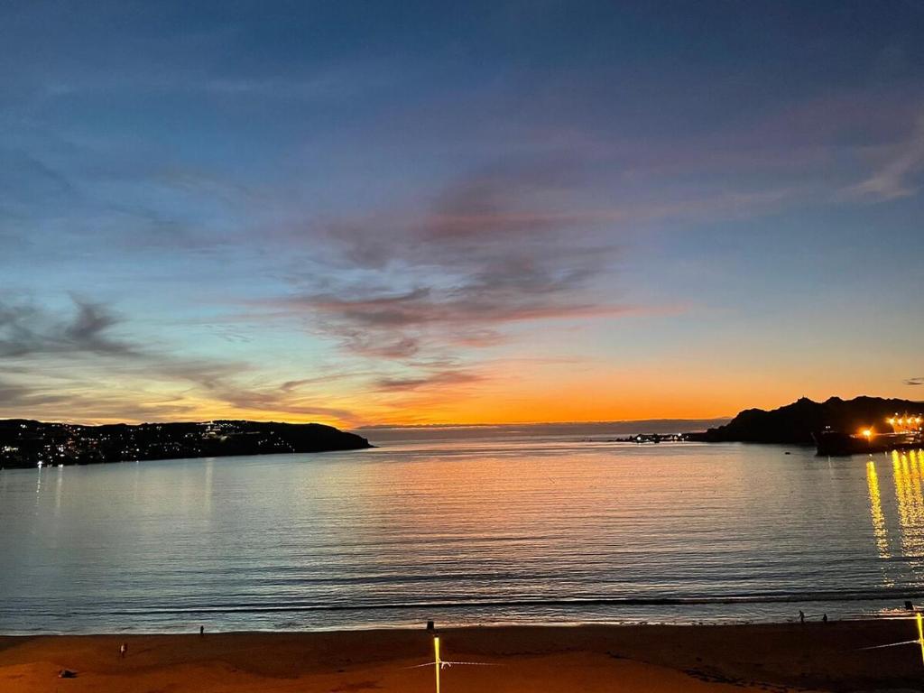a sunset over a body of water with a beach at La Herradura Mágica descansa y disfruta en familia in Coquimbo
