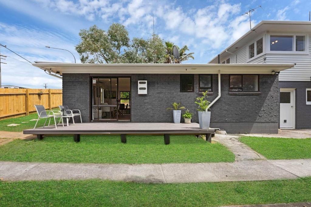 een huis met een bankje ervoor bij Henderson Oasis in Auckland