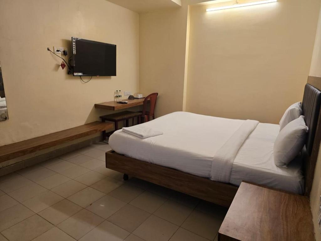 a bedroom with a bed and a desk and a tv at Hotel GT Galaxy in Chennai