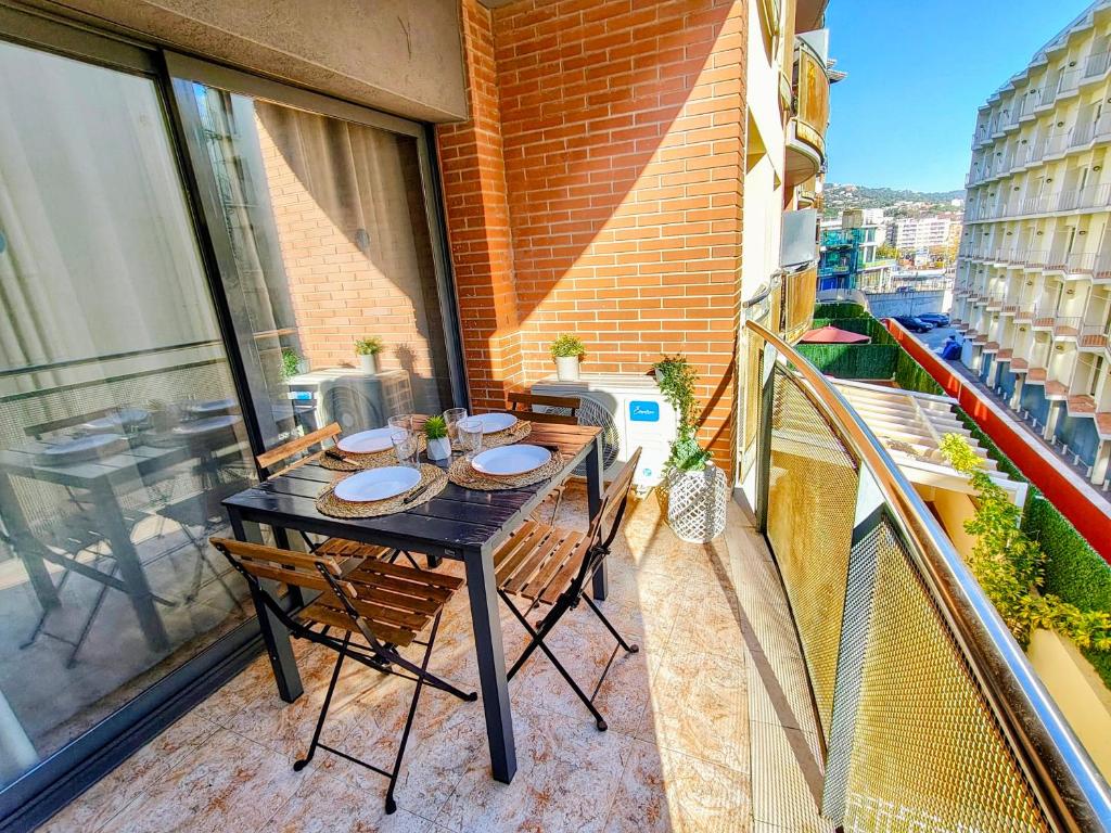 a balcony with a black table and chairs on a balcony at CBN Apartments in Lloret de Mar
