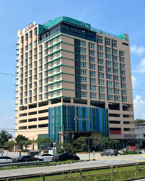 a large building with cars parked in front of it at Amerin Hotel Johor Bahru in Johor Bahru