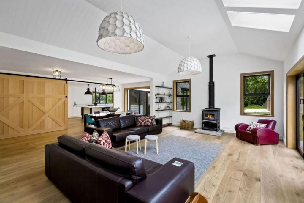 a living room with a couch and a fireplace at Lakeside Bliss Homestead with outdoor spa in Queenstown