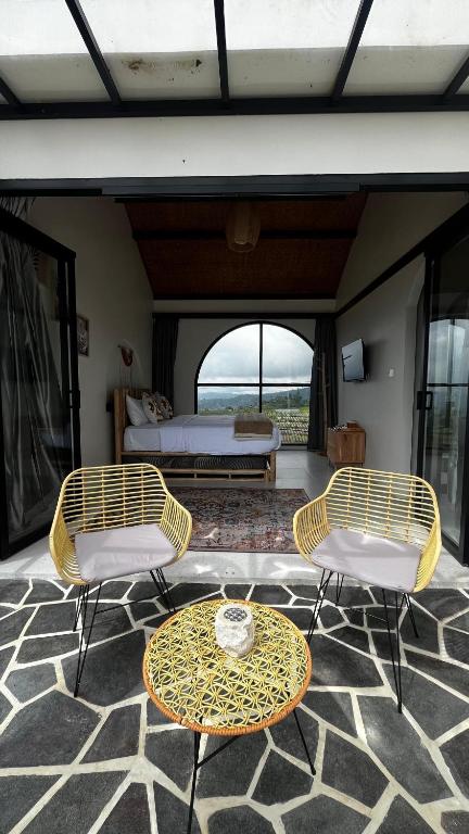a room with two chairs and a table and a bed at HappyNest Glamping and Villa Dieng in Garung