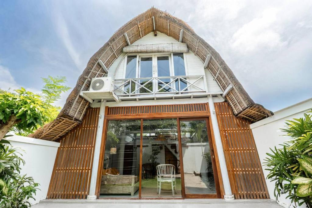 een huis met een grote glazen deur bij Villa Tropical A in Uluwatu