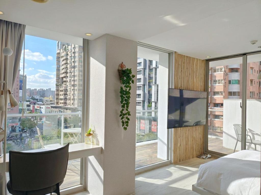 um quarto com uma cama, uma escrivaninha e janelas em Hotel Mapp em Taichung