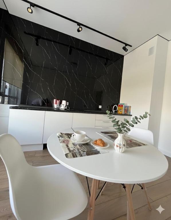 a white dining room with a white table and white chairs at RAISSON A-HOTELG32 KHAN SHATyR in Astana