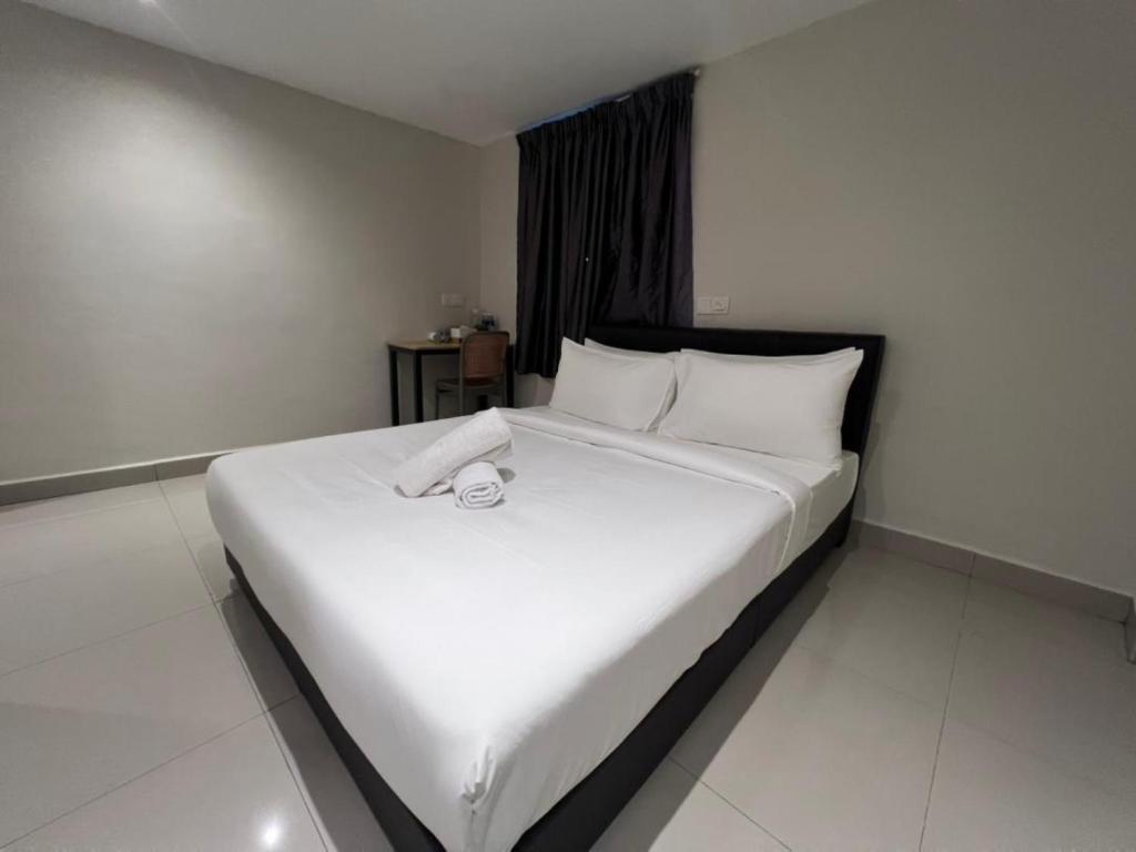 un grand lit blanc dans une chambre d'hôtel dans l'établissement Swing & Pillows - Kajang, Selangor, à Kajang