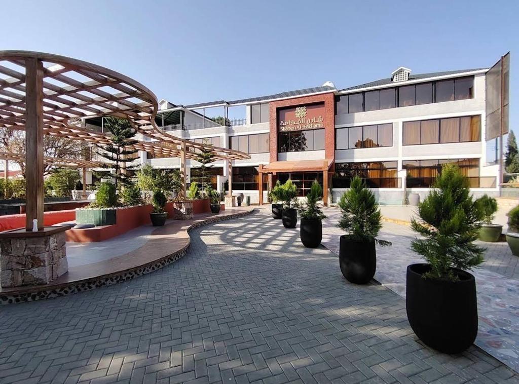 een binnenplaats met potplanten voor een gebouw bij فندق شادن الفخامة in Taif