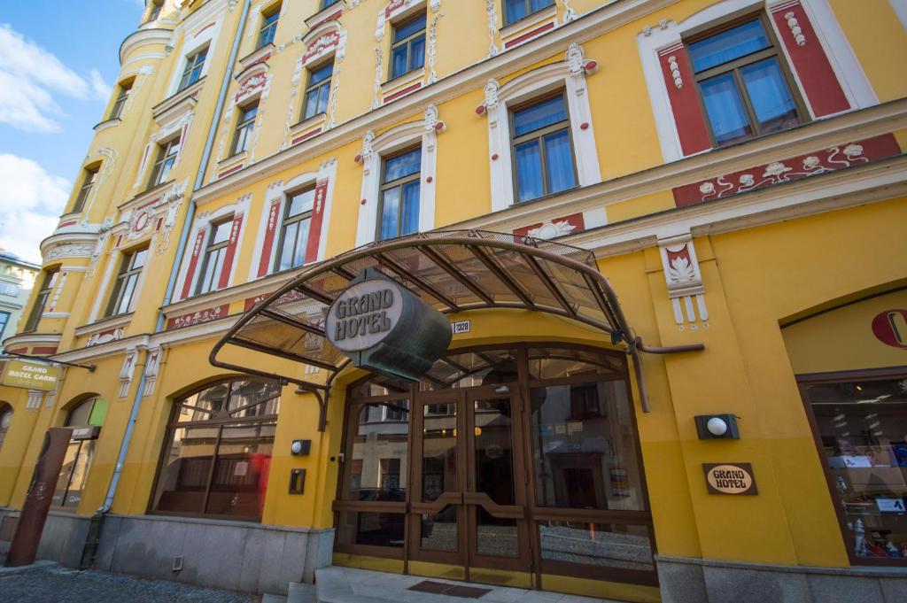 un edificio amarillo con un cartel delante en Grandhotel Garni en Jihlava