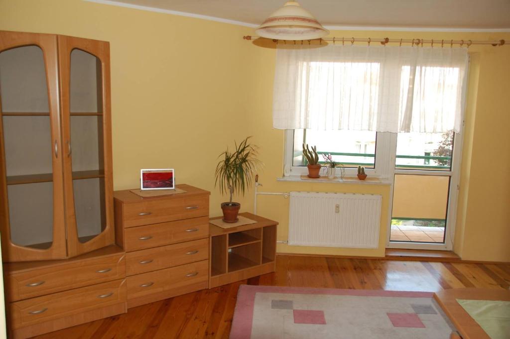a bedroom with a dresser and a large window at Apartament Rodzinny w Kaliszu in Kalisz