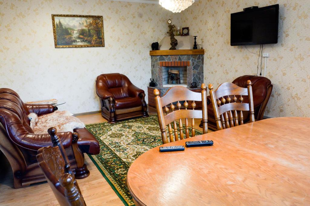 GutaにあるСадыба Полыцькаのリビングルーム(テーブル、椅子、暖炉付)