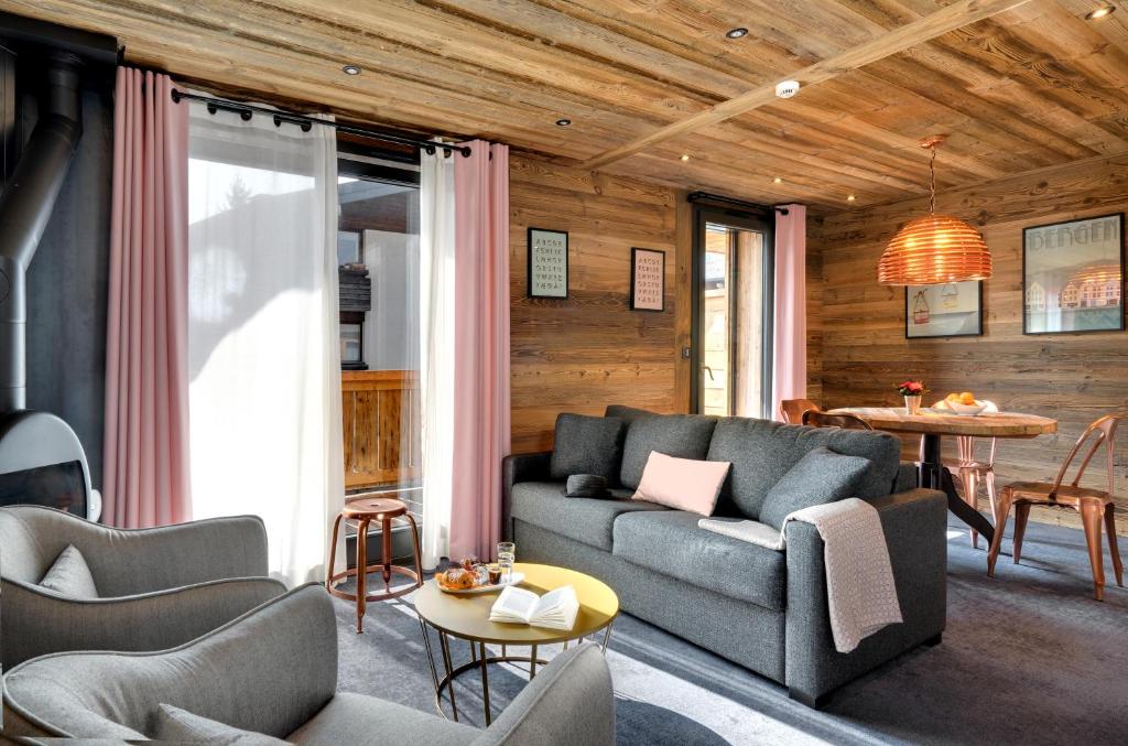 a living room with a couch and a table at Chalet-Hôtel La Marmotte, La Tapiaz & SPA, The Originals Relais in Les Gets