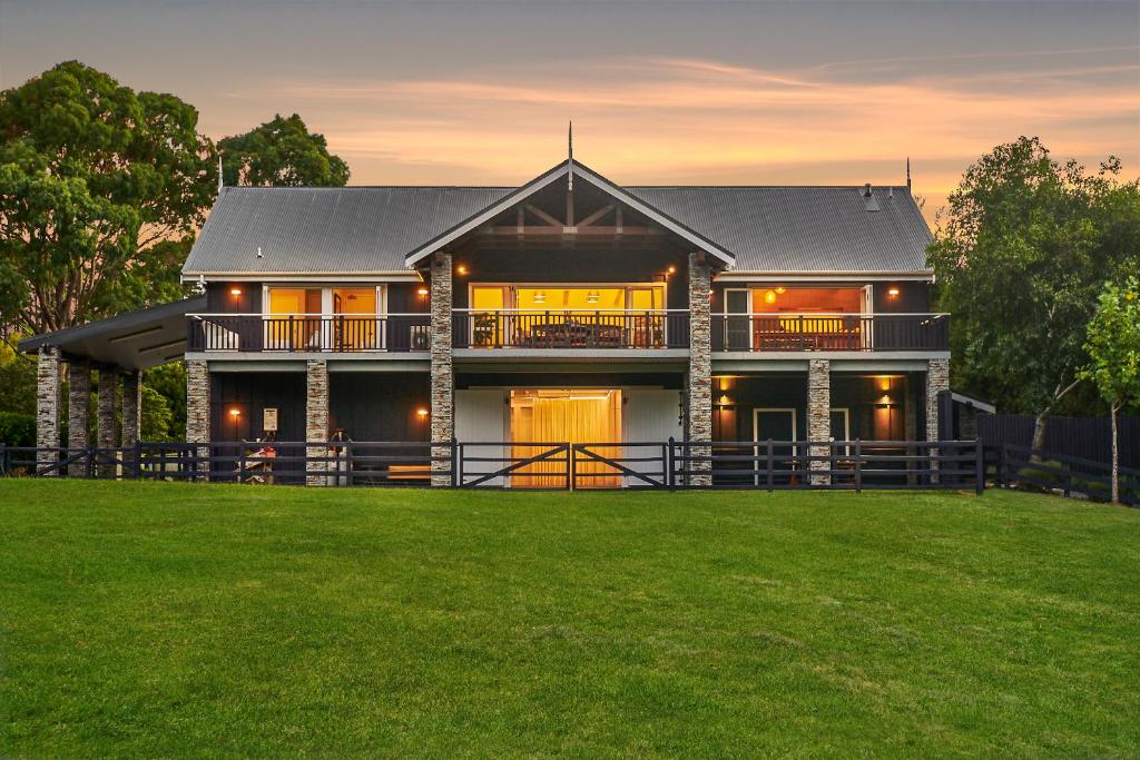 una casa grande con un campo de hierba delante de ella en HUs - Boutique Venue & Accommodation, en Riverhead