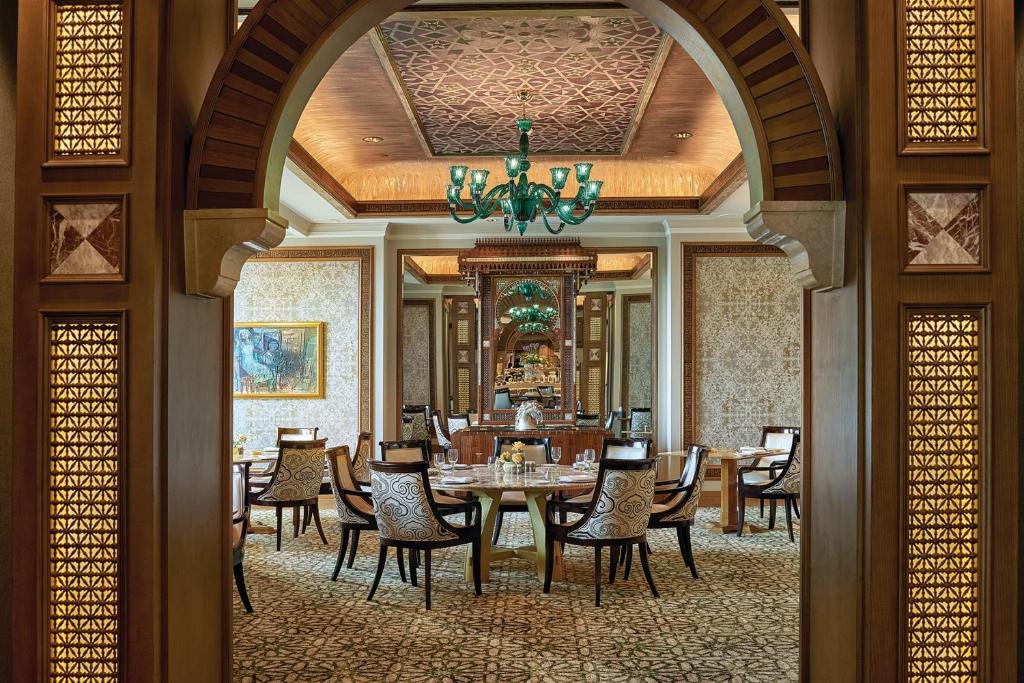 a dining room with a table and chairs and a chandelier at Four Seasons Hotel Cairo at Nile Plaza in Cairo