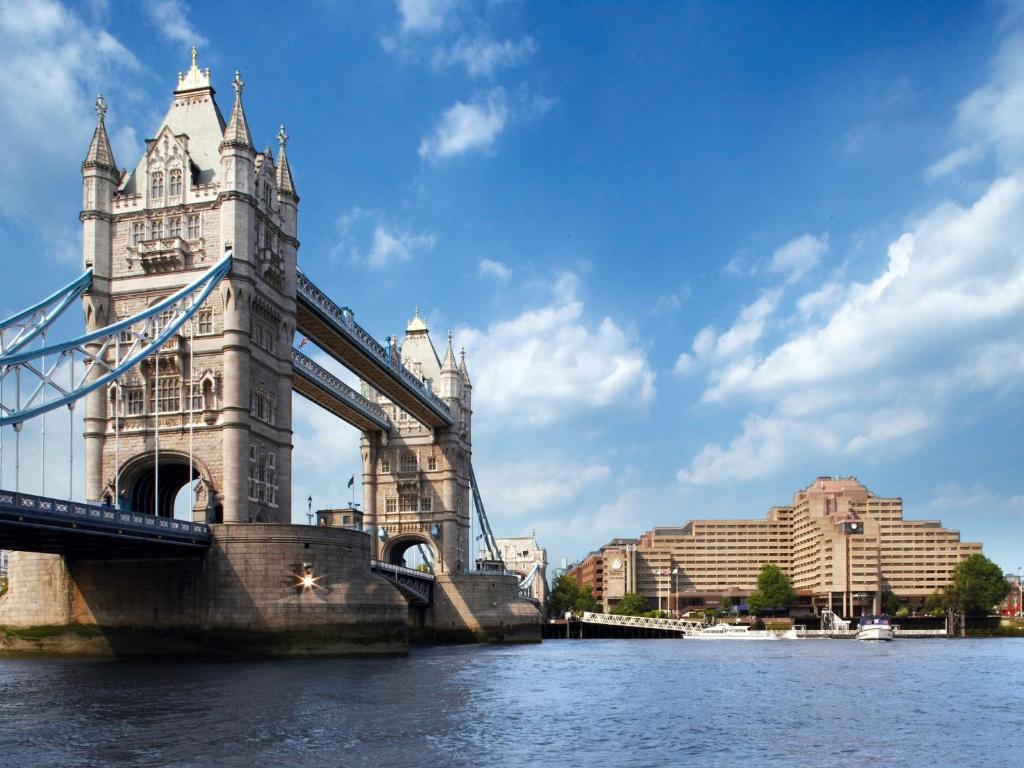 a suspension bridge over water with buildings in the background at The Tower Hotel, by Thistle in London