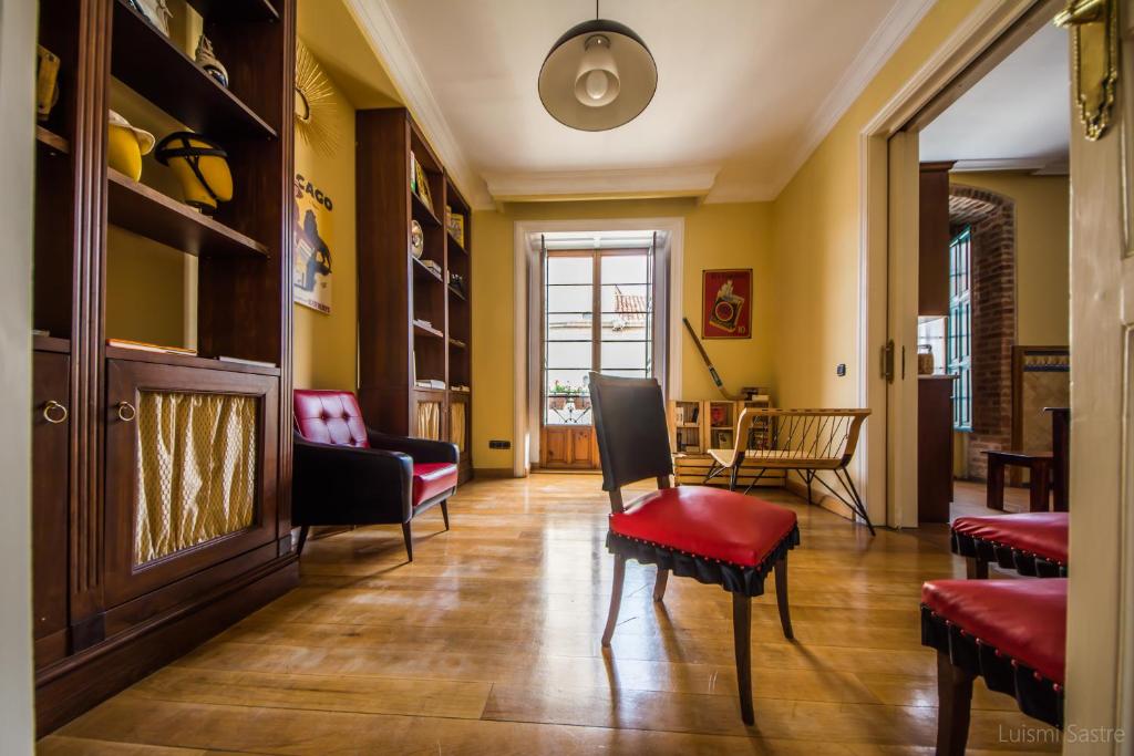 a living room with yellow walls and red chairs at Hostel Covent Garden in León