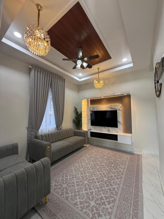 een woonkamer met een bank en een open haard bij Eyqa Homestay Pasir Mas in Pasir Mas