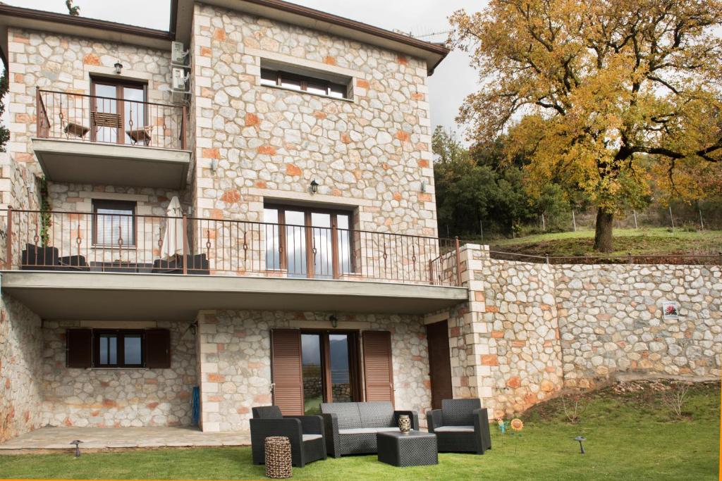 een stenen gebouw met zwarte stoelen ervoor bij Τα πέτρινα στο Σκεπαστό in Kalavrita
