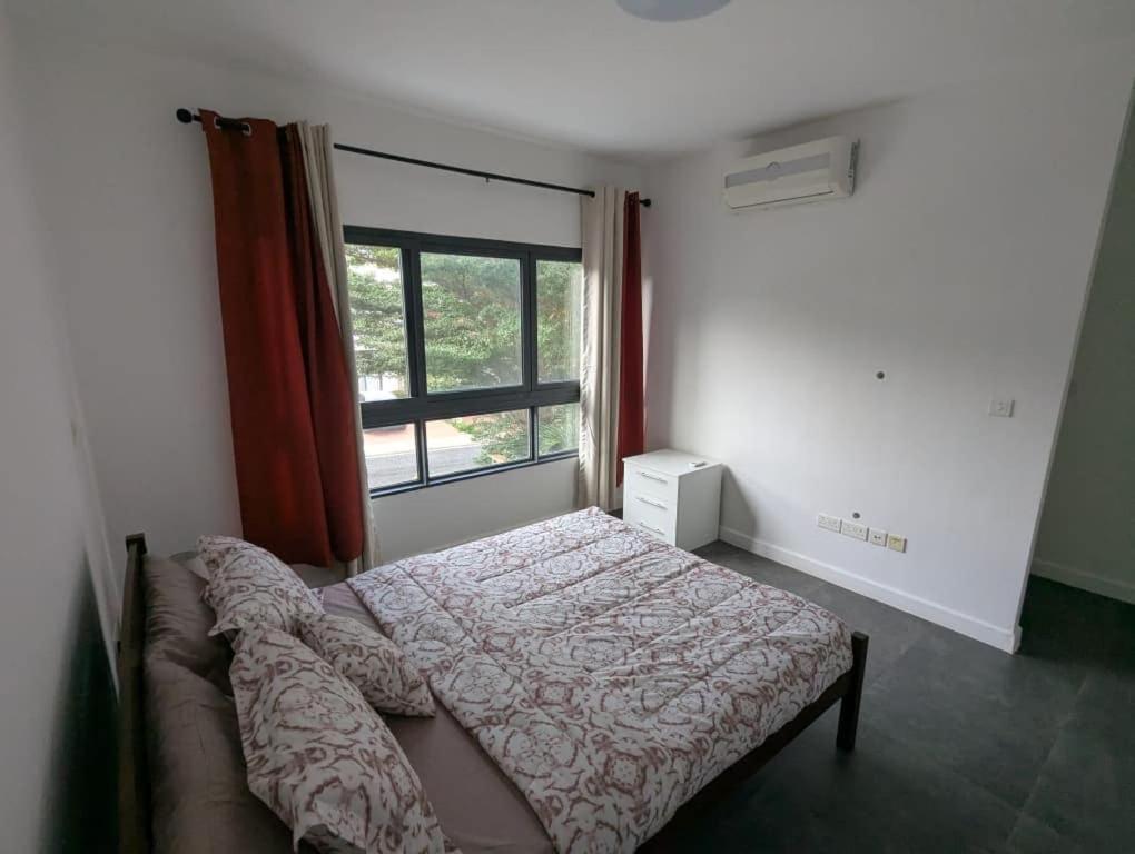 um quarto com uma cama e uma janela em 2 Bedroom House at Ayi Mensah Park em Aiyimensa