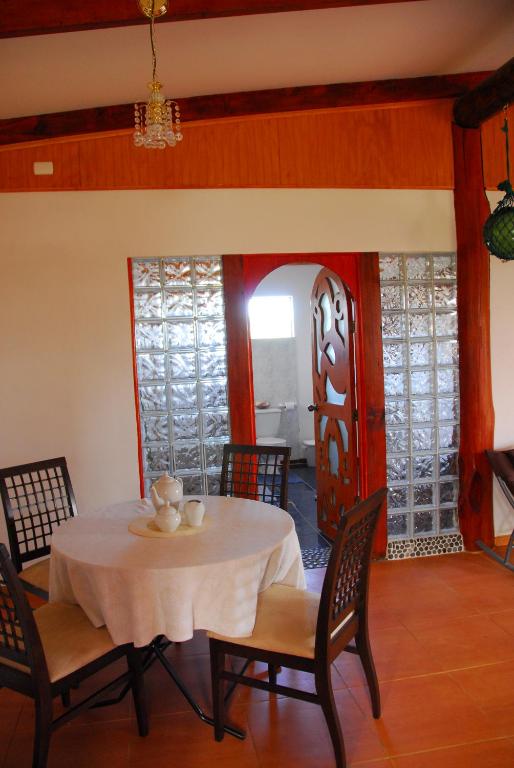 a dining room with a table and chairs and a red door at Cabañas Moai in Hanga Roa