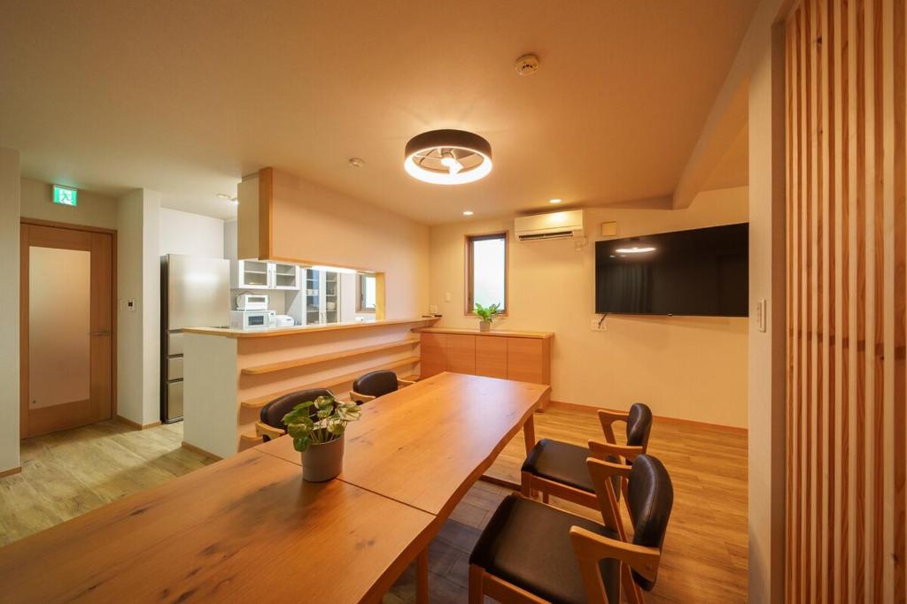 a dining room with a wooden table and chairs at Triangle 2nd in Beppu