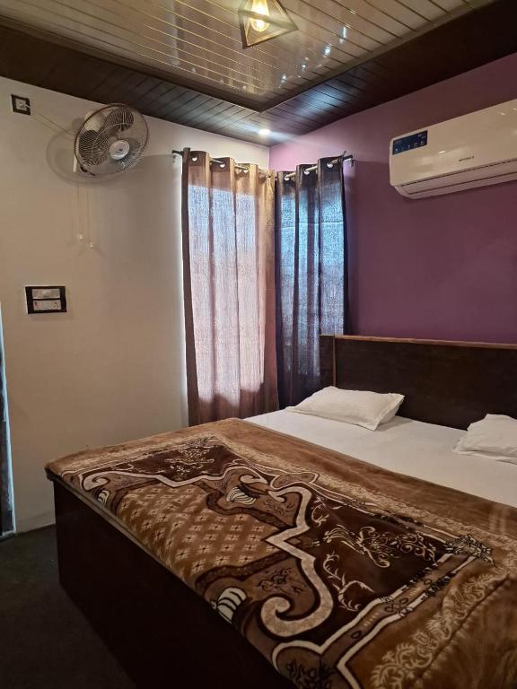 a bedroom with a large bed with purple walls at Gorakhnath Guest House in Gorakhpur