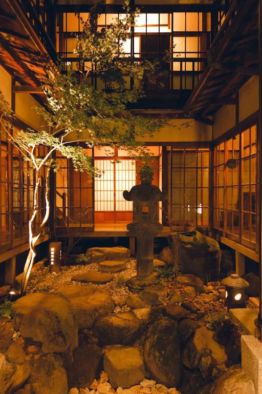 a japanese garden with a fountain in a building at 千秋楽 in Tamano
