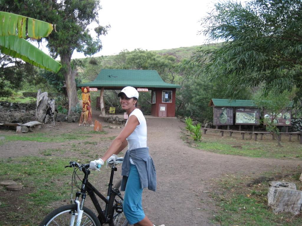 a young woman is posing with a bike at Cabañas Moai in Hanga Roa