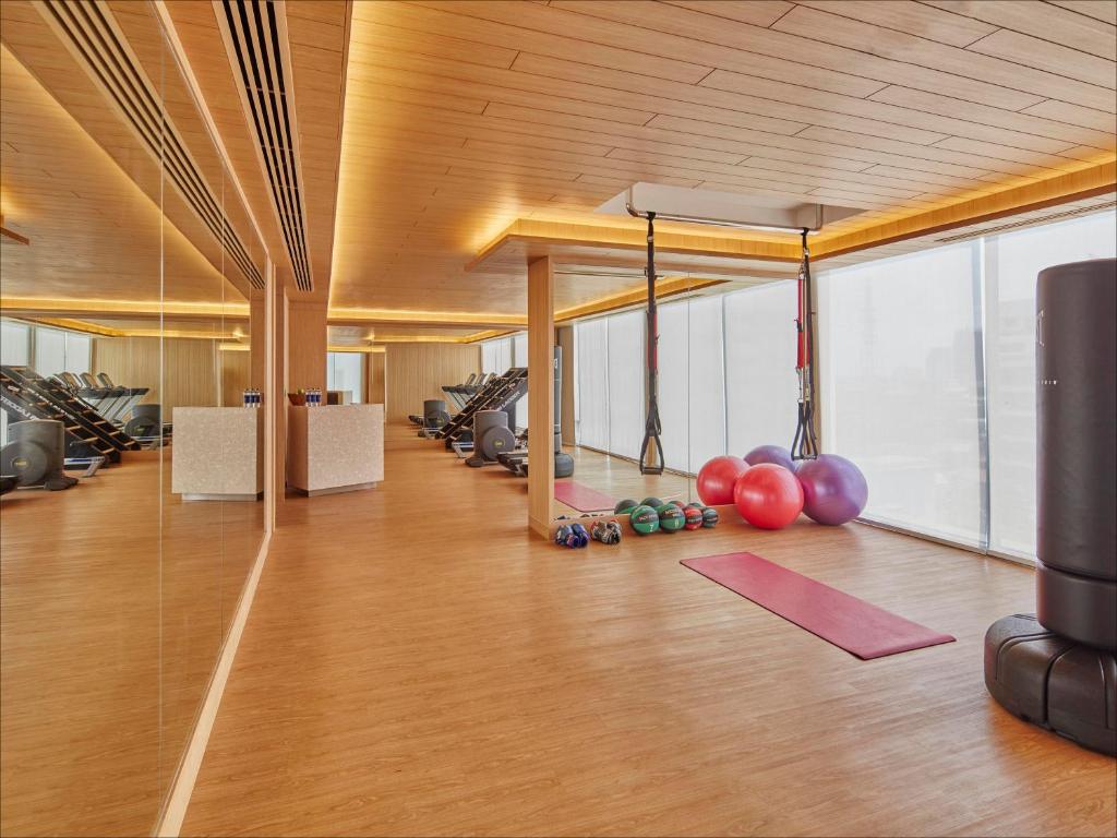 Wood-panelled fitness studio with cardio machines, free weights and suspension equipment.
