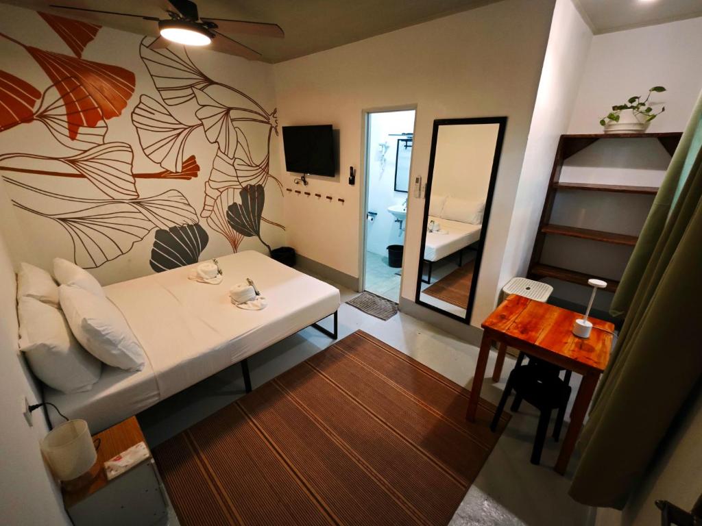 ein Wohnzimmer mit einem weißen Sofa und einem Spiegel in der Unterkunft Gubat Apartelle in Lalao