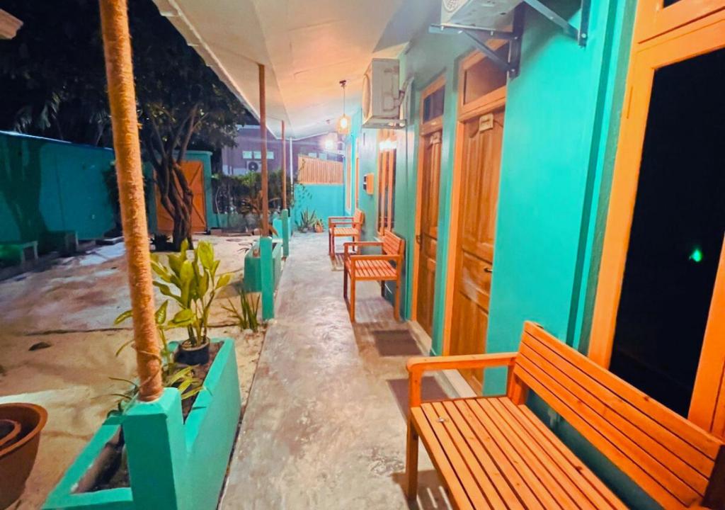 a row of benches sitting outside of a building at Kandoo Cozy Family Room in Huraa