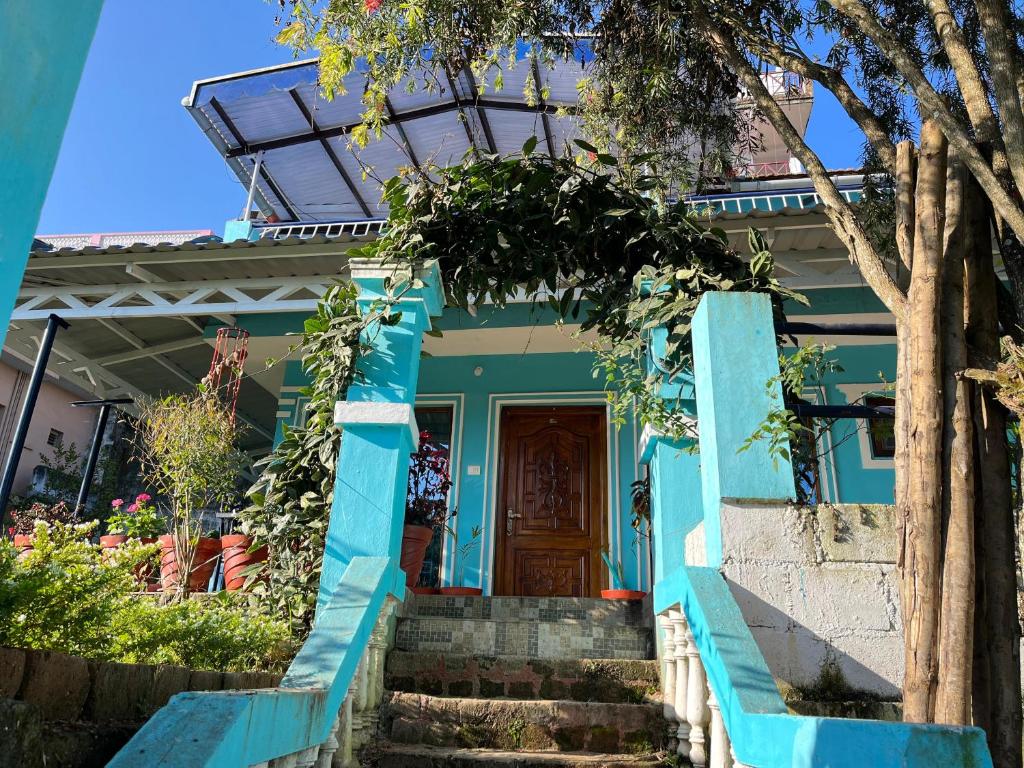 a blue house with stairs leading to the front door at Sparrow valley in Coonoor