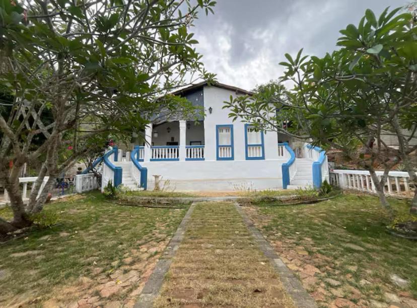 a blue and white house with trees in front of it at Recanto Cravo & Canela in Meruoca