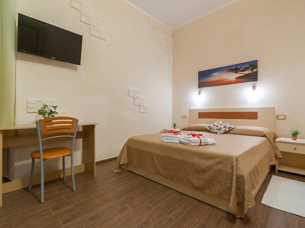 een slaapkamer met een bed en een bureau met een stoel bij Il Borgo House in Cagliari