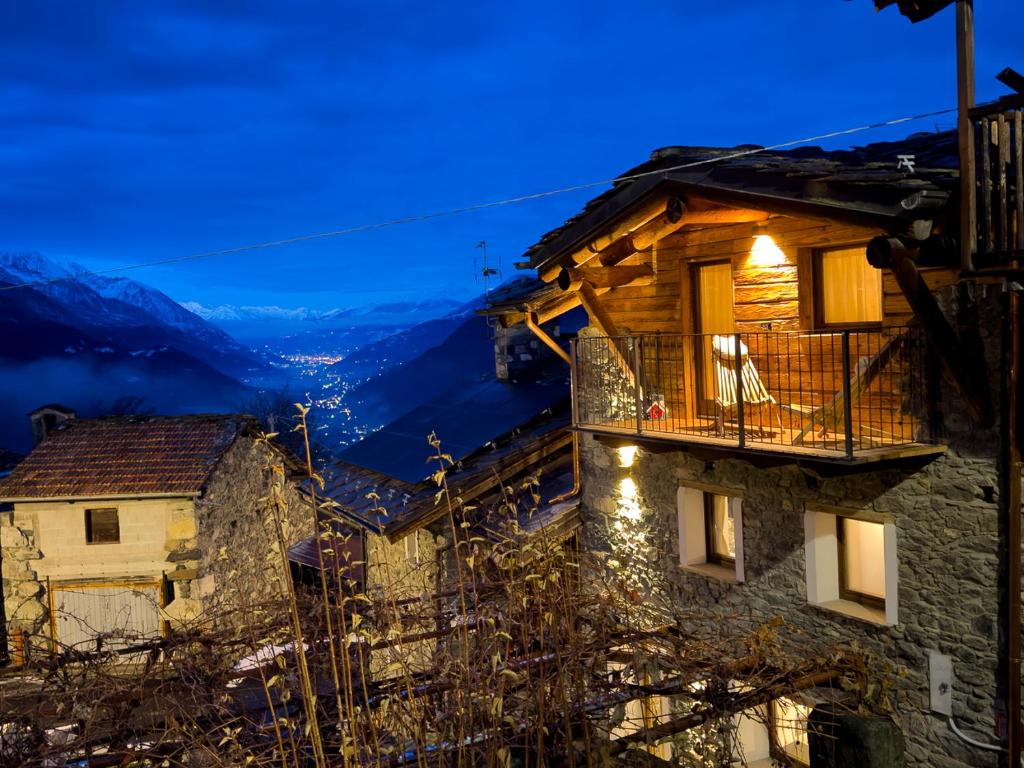 un edificio con balcone affacciato sulle montagne di Little Wild House a Saint Vincent