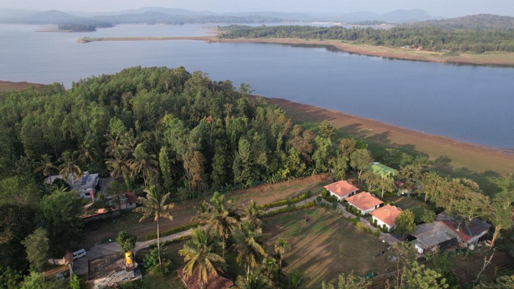 an aerial view of a house on a hill next to a lake at Coorg Backwaters in Suntikoppa