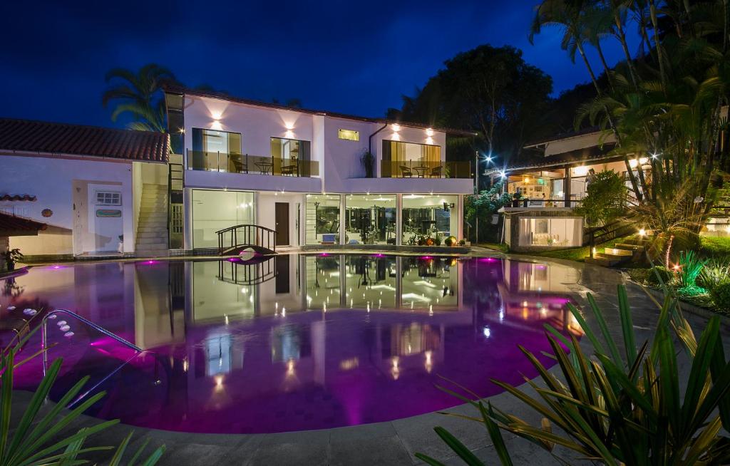 una casa con piscina por la noche en Angra Boutique Hotel en Angra dos Reis