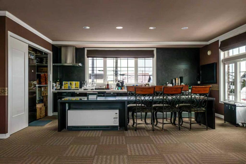 美瑛町Biei Terrace 2F 専用玄関 127平米 85型スマートTV -駅前通り&景観条例地区-的厨房里有一张桌子和几把椅子