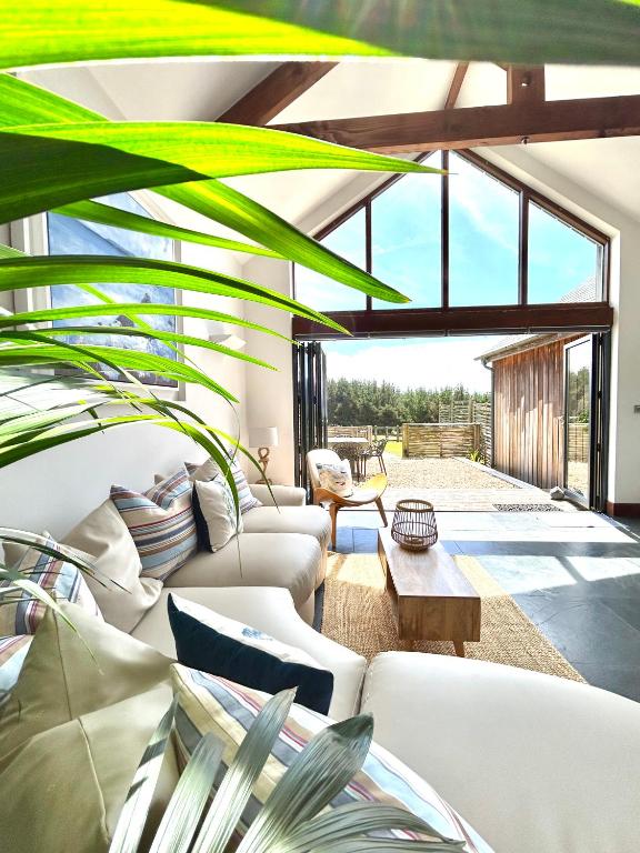 a living room with white furniture and a large window at Merlin Farm Cottages short walk to Mawgan Porth Beach and central location in Cornwall in Mawgan Porth